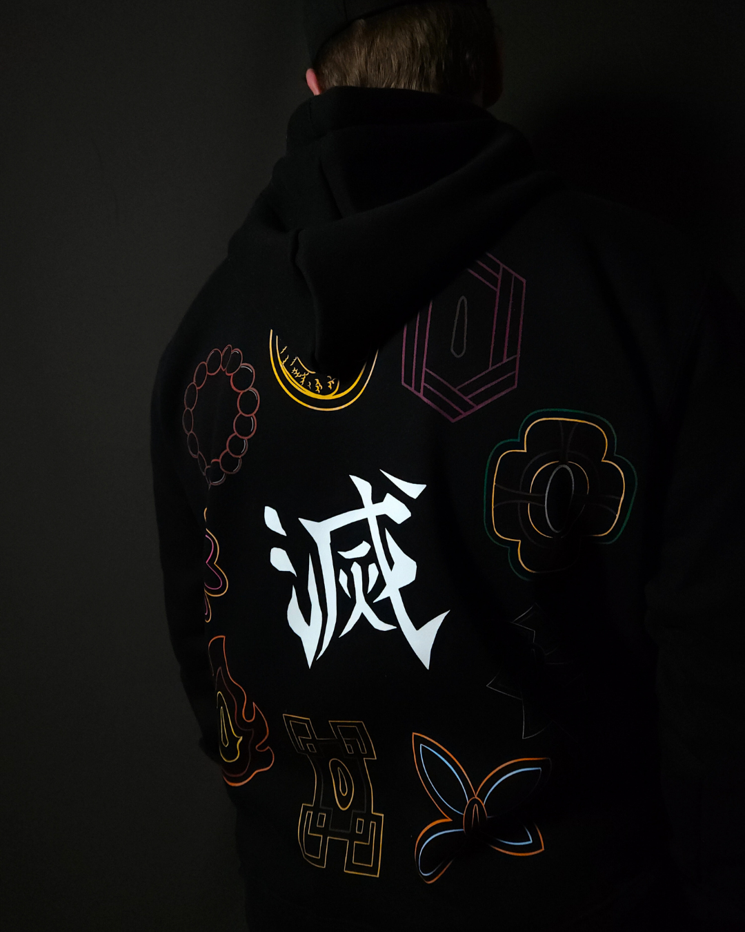Anime-inspired apparel featuring bold back artwork, worn by a model in a dark studio setting – from a South African anime clothing brand.