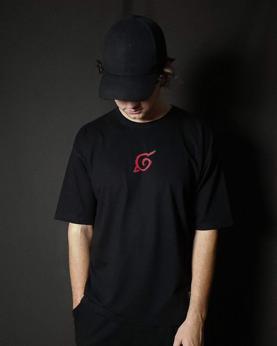 Anime-inspired apparel featuring bold Naruto back artwork, worn by a model in a dark studio setting – from a South African anime clothing brand.