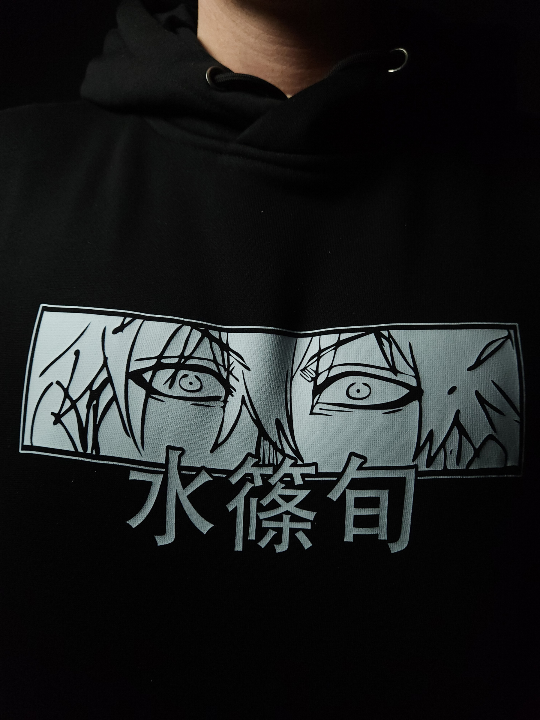 Anime-inspired apparel featuring bold back artwork, worn by a model in a dark studio setting – from a South African anime clothing brand.
