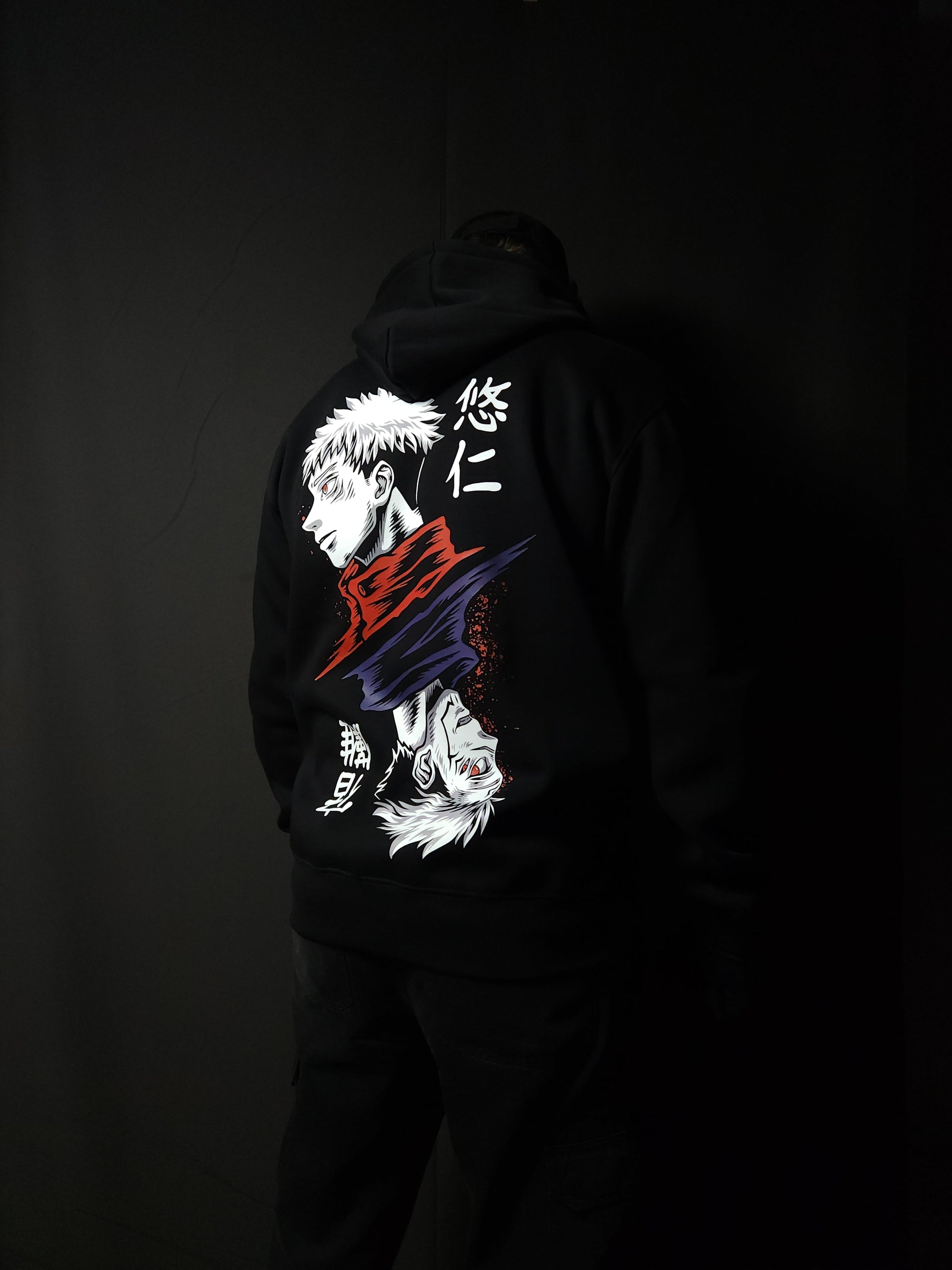 Anime-inspired apparel featuring bold back artwork, worn by a model in a dark studio setting – from a South African anime clothing brand.