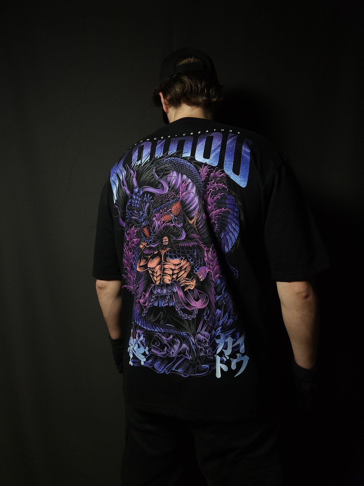 Anime-inspired apparel featuring bold back artwork, worn by a model in a dark studio setting – from a South African anime clothing brand.