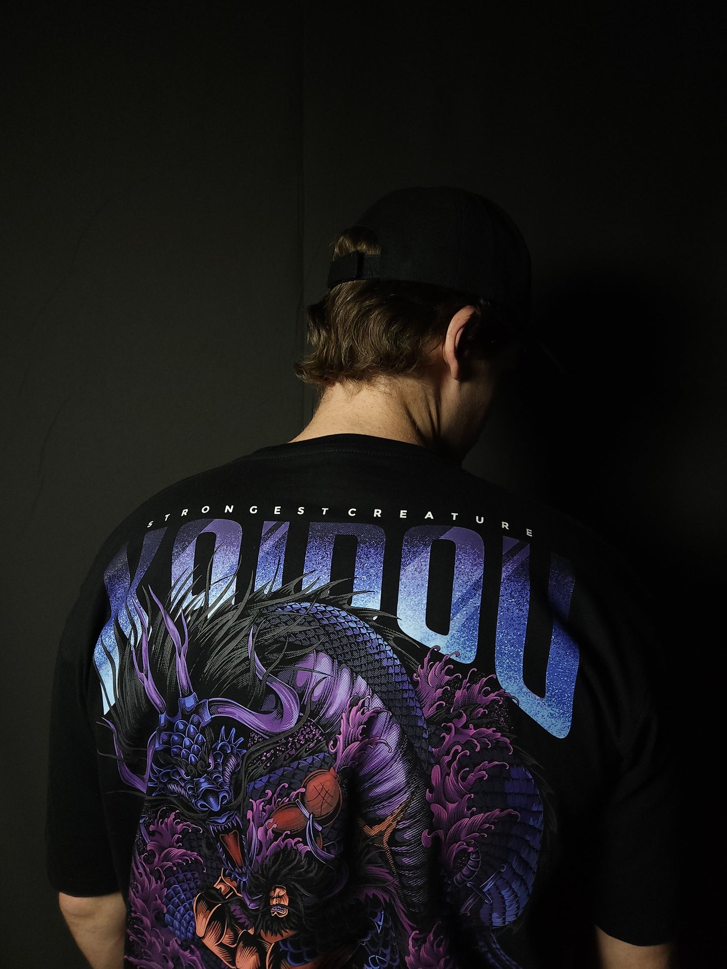 Anime-inspired apparel featuring bold back artwork, worn by a model in a dark studio setting – from a South African anime clothing brand.