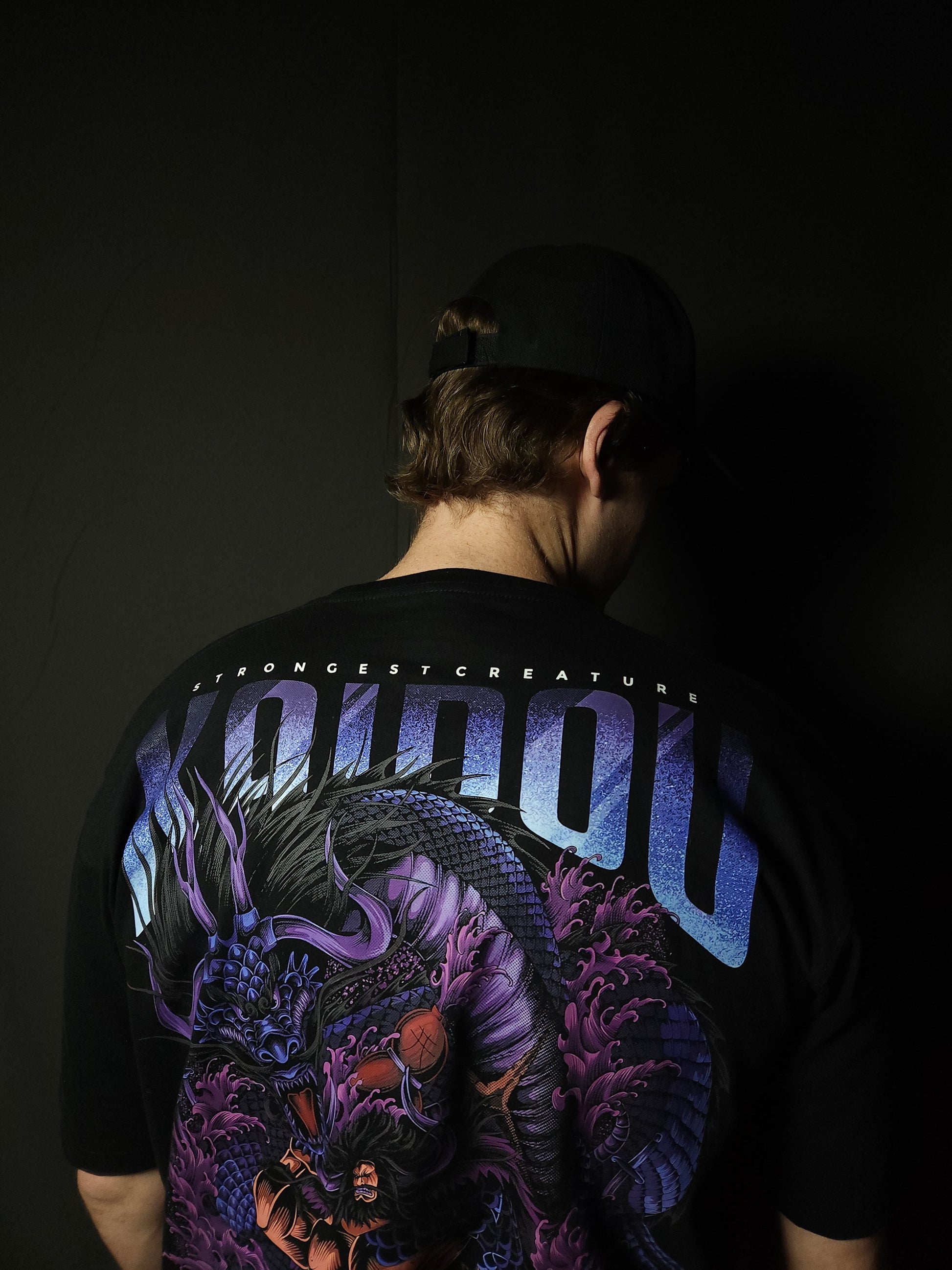 Anime-inspired apparel featuring bold back artwork, worn by a model in a dark studio setting – from a South African anime clothing brand.