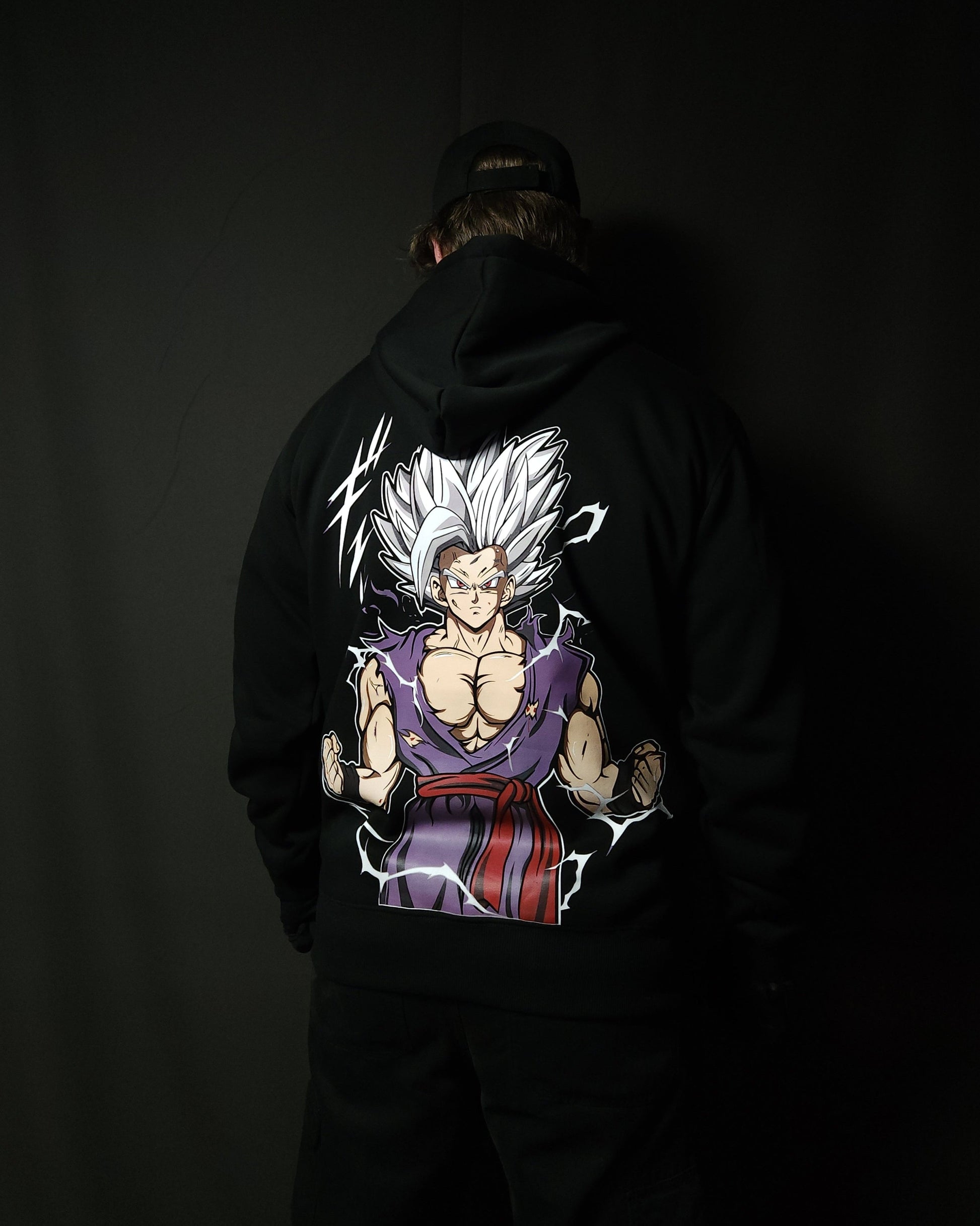 Anime-inspired apparel featuring bold back artwork, worn by a model in a dark studio setting – from a South African anime clothing brand.