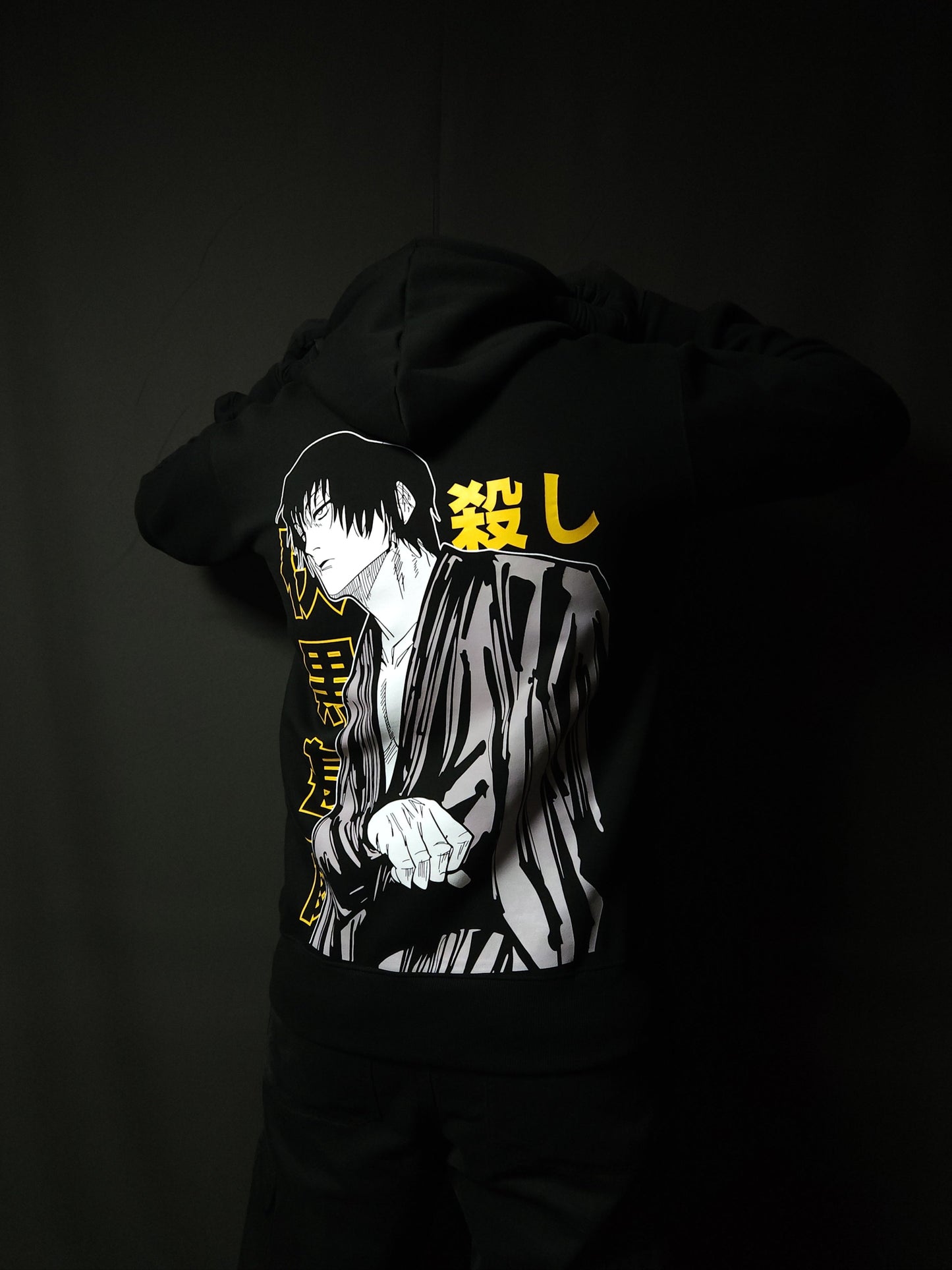Anime-inspired apparel featuring bold back artwork, worn by a model in a dark studio setting – from a South African anime clothing brand.